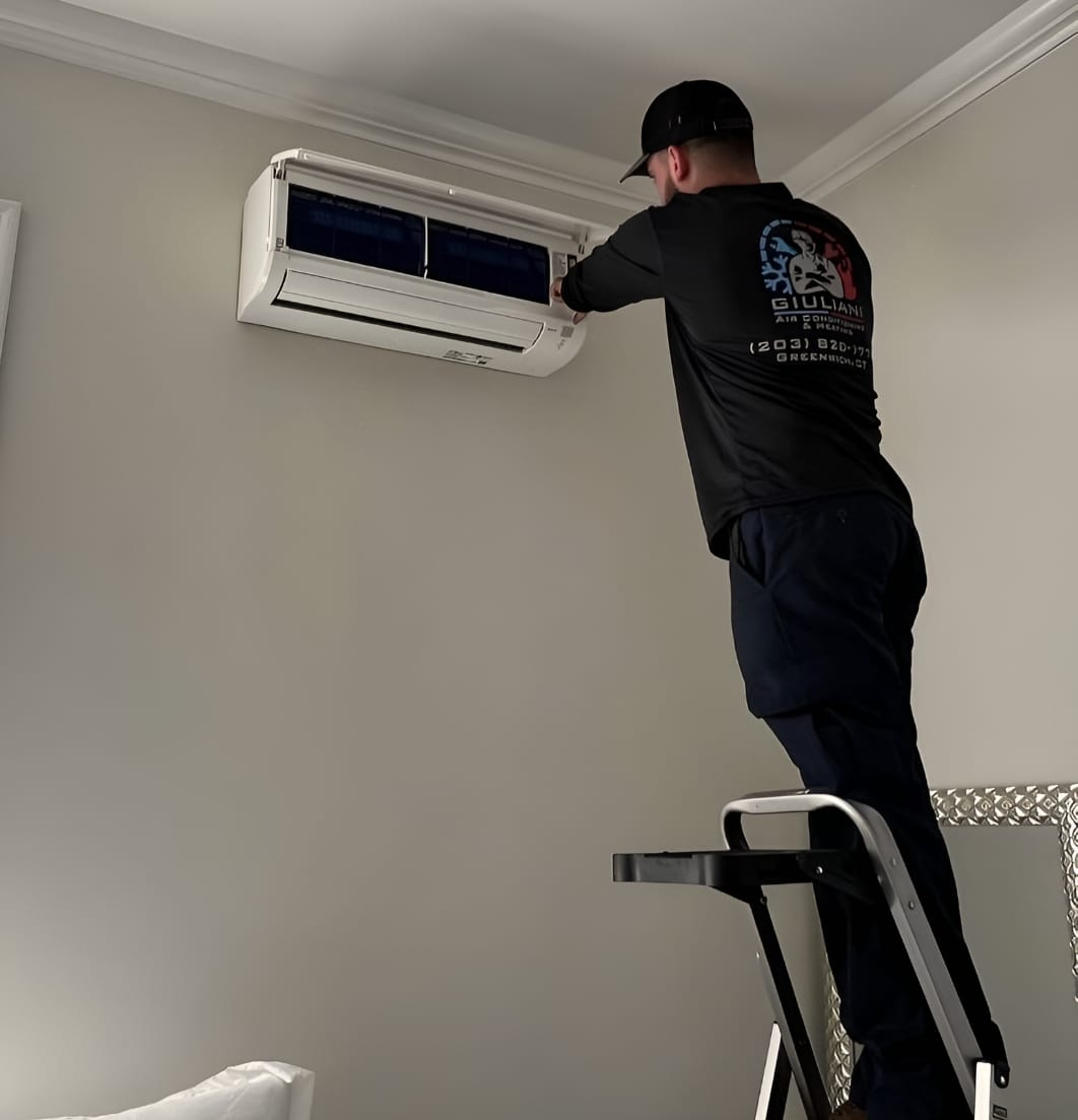 jack giuliani on step ladder working on mini split unit