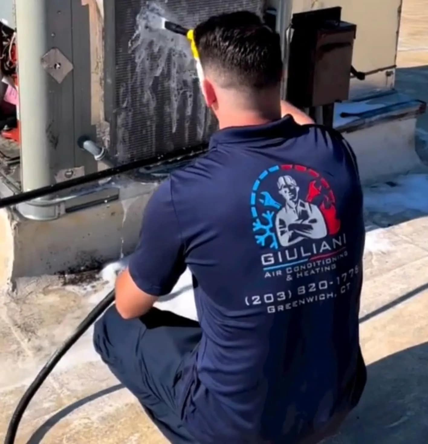 Jack Giuliani hosing an AC condenser