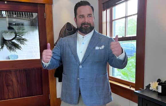 Christopher Rice, client of Cheryl Petteruti's wearing a custom plaid blazer giving thumbs up